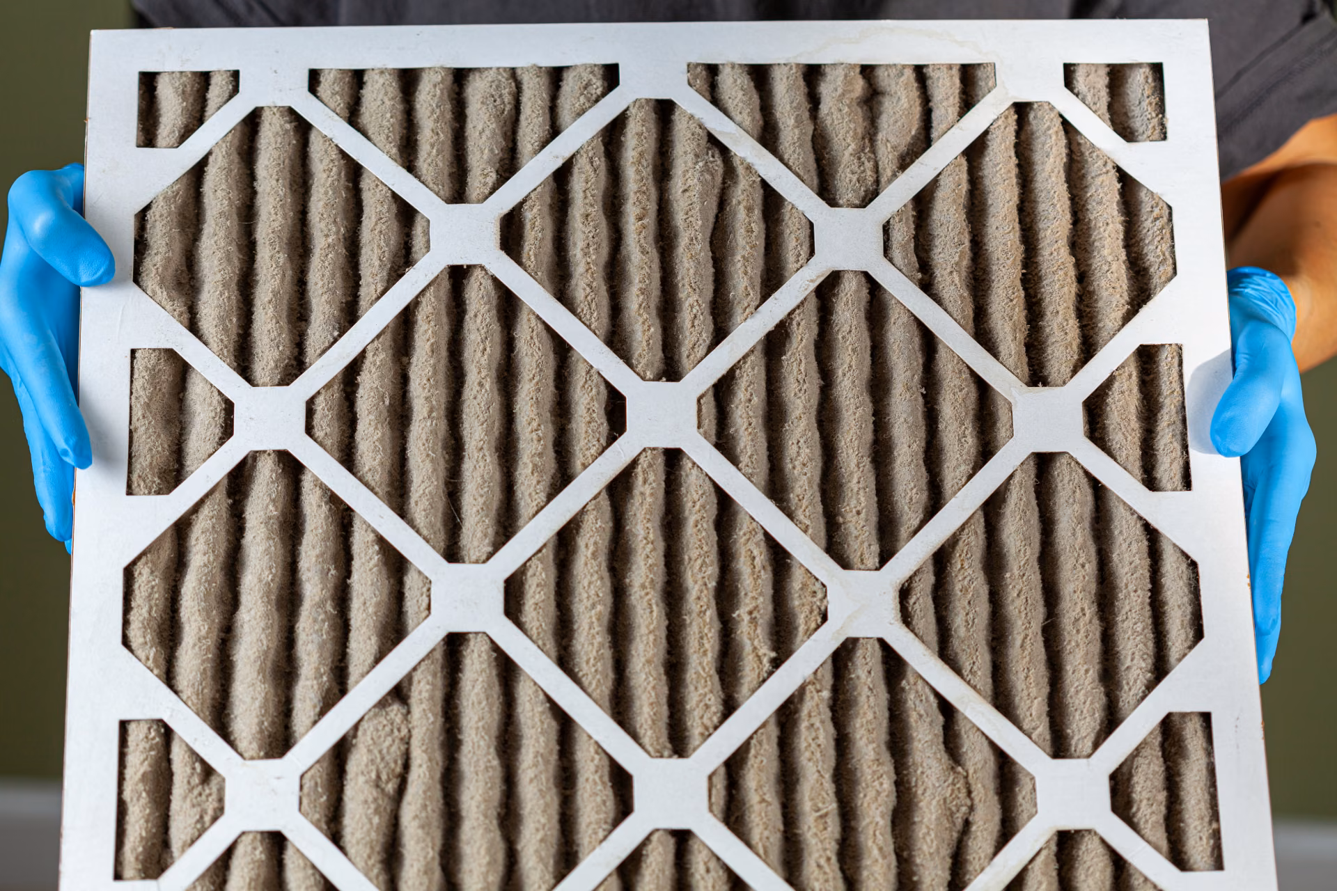 Pollen- and dust-clogged HVAC air filter, illustrating how Alabama pollen and humidity affect commercial facility cleaning