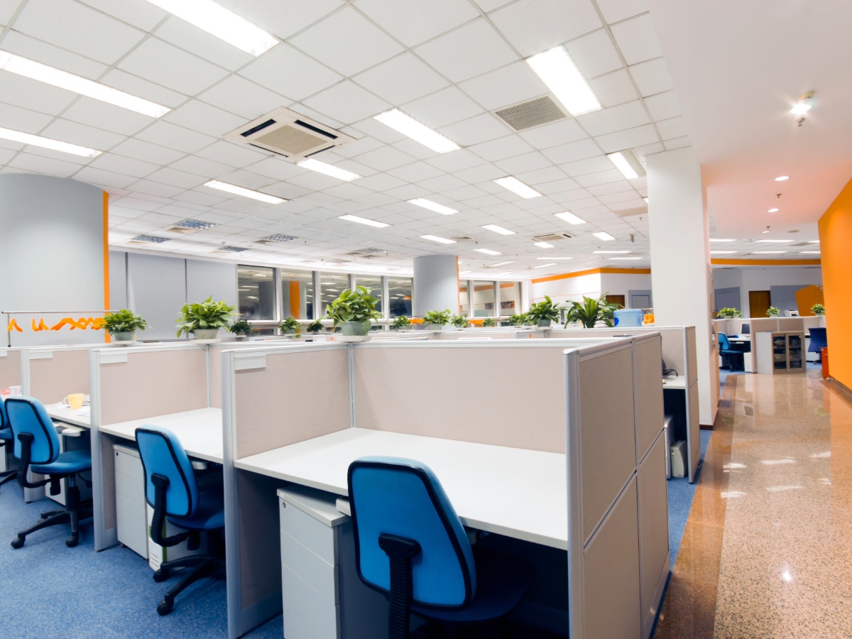 A bright, modern open-plan office with clean cubicles and polished floors