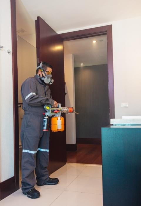 Sweepers technician in PPE performing electrostatic facility sanitizing