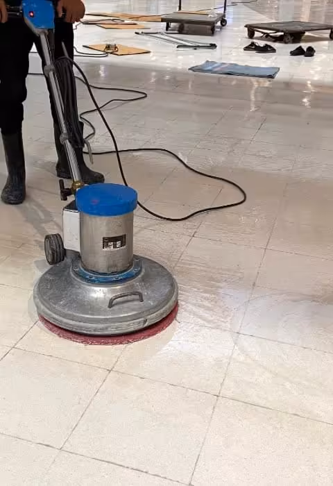 Sweepers crew refinishing a commercial tile floor with a rotary floor buffer